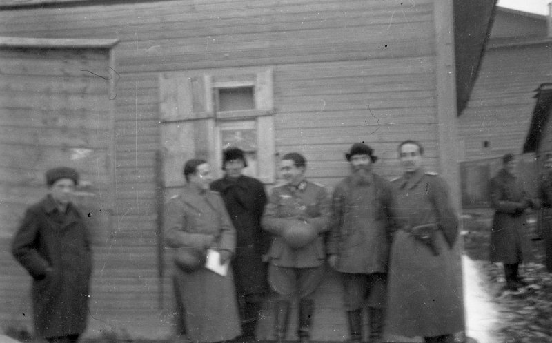 Tres oficiales de la División Azul posan junto a civiles rusos en un pueblo