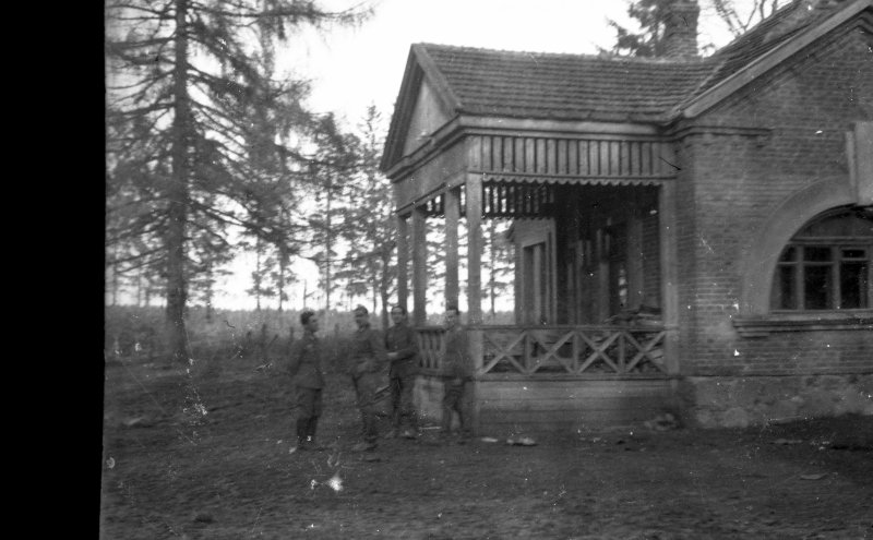 Un grupo de soldados de la División Azul frente a una casa de campo