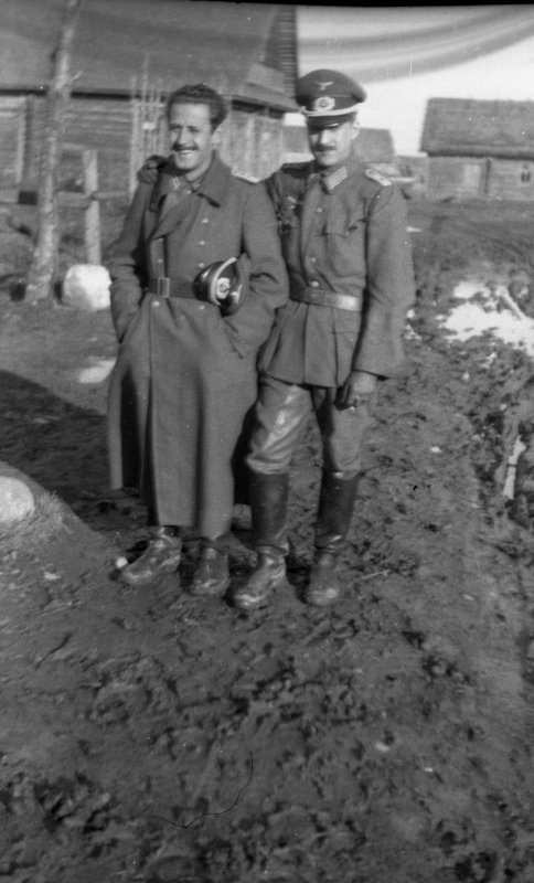 Dos oficiales de la División Azul junto a unas cabañas o barracones