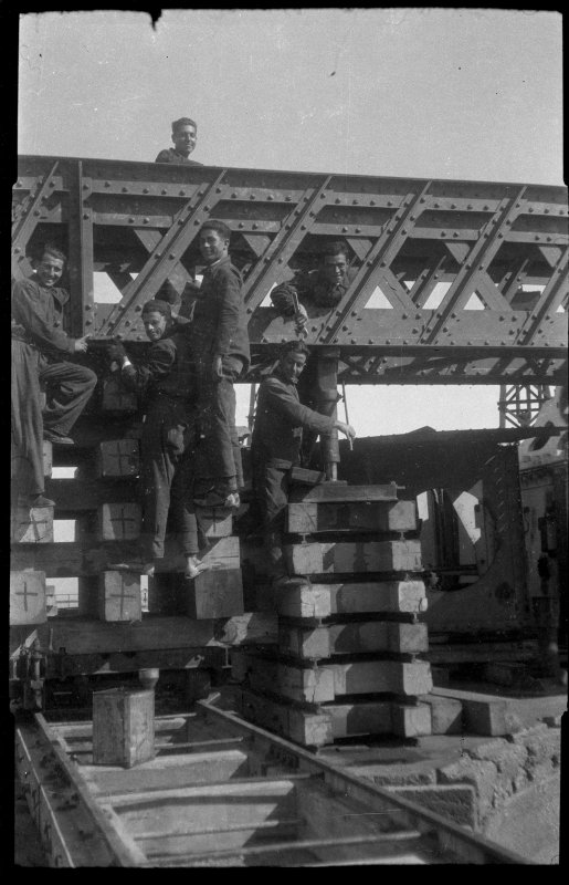 Retrato de un grupo de operarios posando en la estructura de un puente grúa