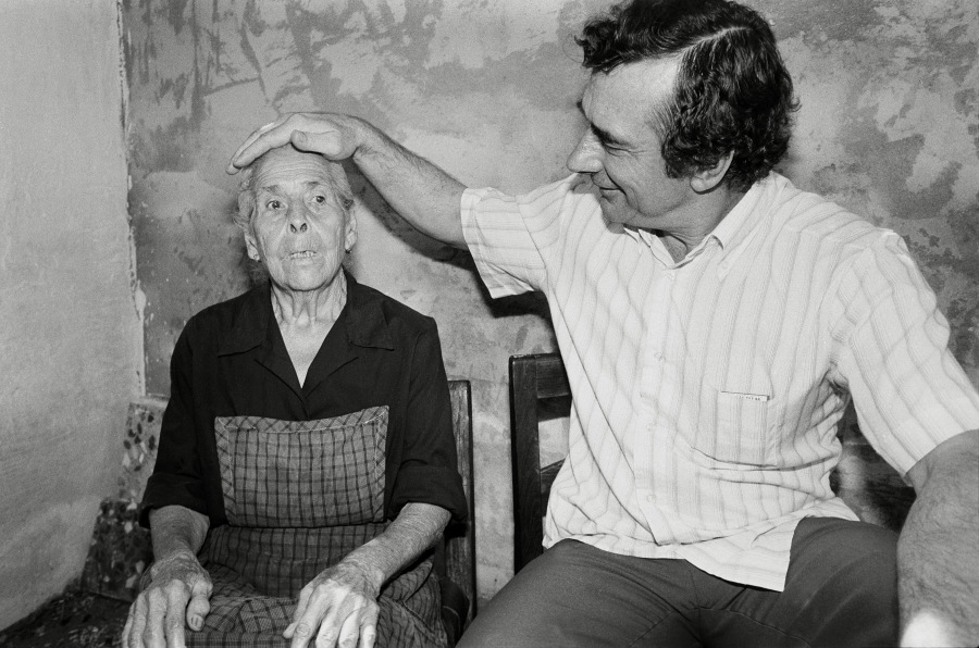 Primitivo, curandero de El Raal, posa su mano sobre la cabeza de una anciana a la que pretende curar, en septiembre de 1980