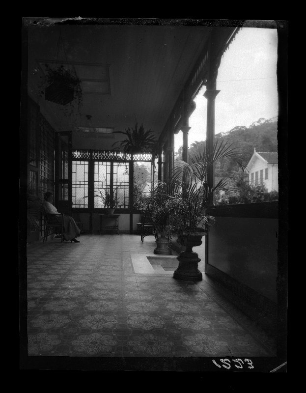 Vista del porche sur de la casa de Gillman en Petrópolis, con una mujer sentada en el mismo