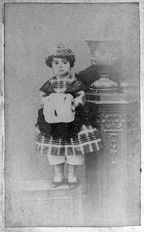 Retrato de niña con vestido a cuadros.