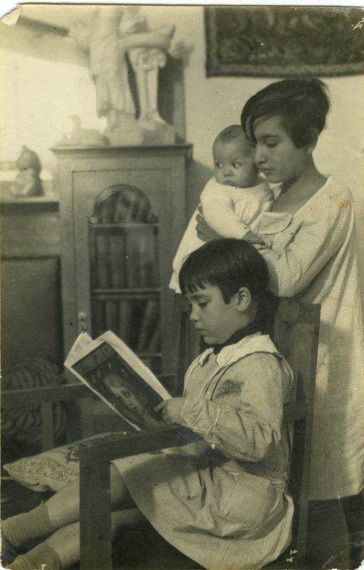 Retrato de niños leyendo 'La semana gráfica' en casa.