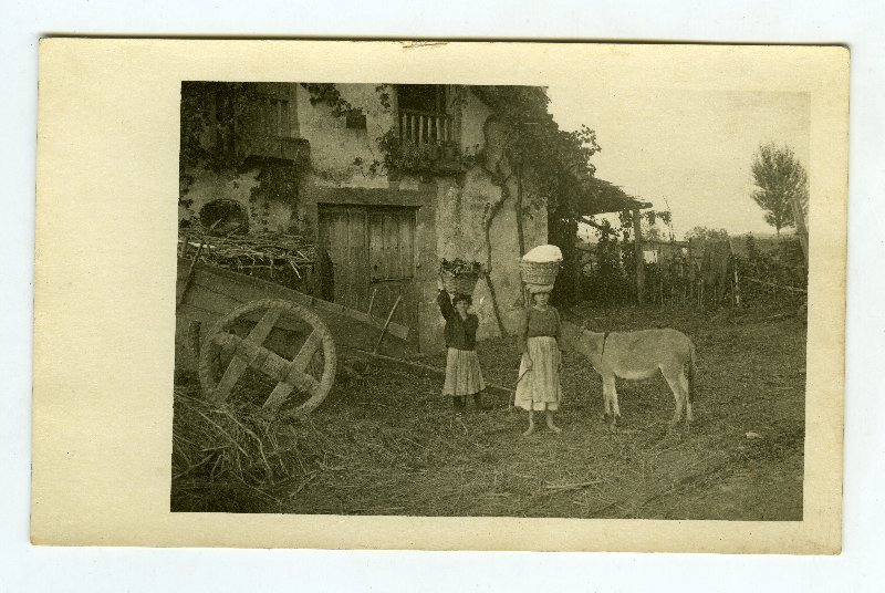 Dos niñas aldeanas junto a una casa campesina en Laredo
