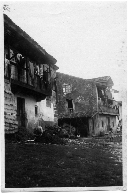 Vista de una calle, con dos viviendas populares, de una localidad no identificada del norte de España