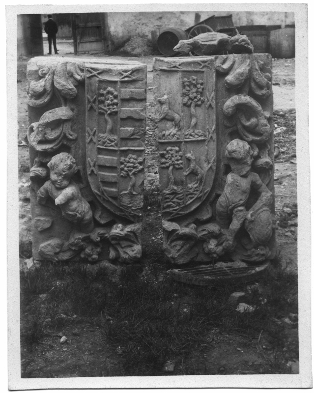 Escudo heráldico en piedra desmontado en dos piezas, ubicado en el patio de una finca