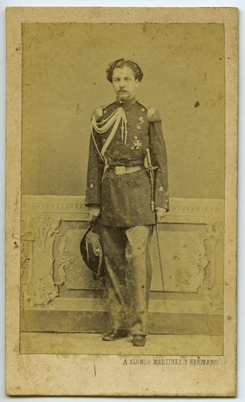 Retrato de estudio de un joven militar en uniforme de gala con sable y distintivo de ayudante de campo.