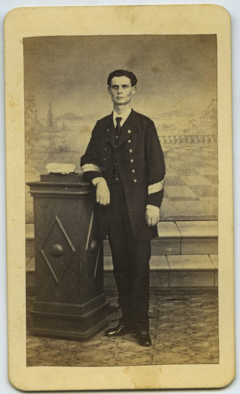 Retrato de estudio de Juan Cuenca de pie, con uniforme de la marina española, apoyado en un pedestal.