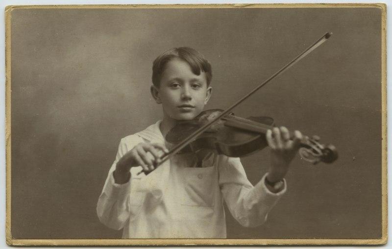 Retrato de estudio del niño Alfredo Robinson Lizana tocando el violín