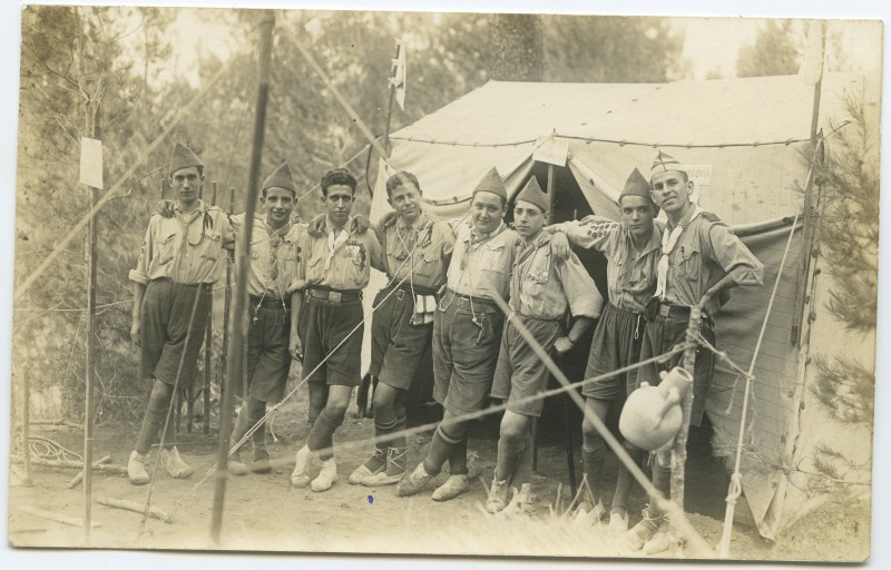 Grupo de exploradores frente a una tienda de campaña