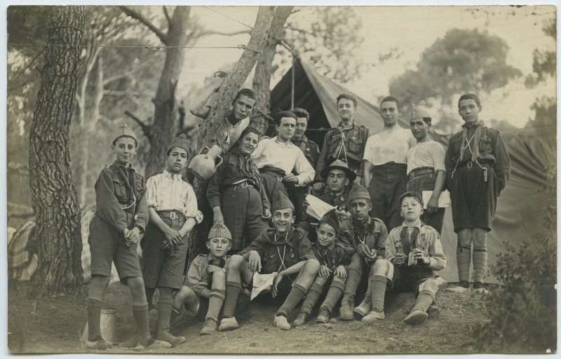 Un grupo de exploradores posa frente a una tienda de campaña