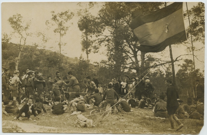 Un grupo de exploradores junto a otras personas en el campo durante un campamento en Espuña