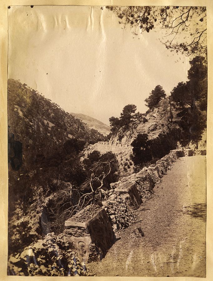 Vista de un camino con quitamiedos de piedra en algún lugar de Sierra Espuña