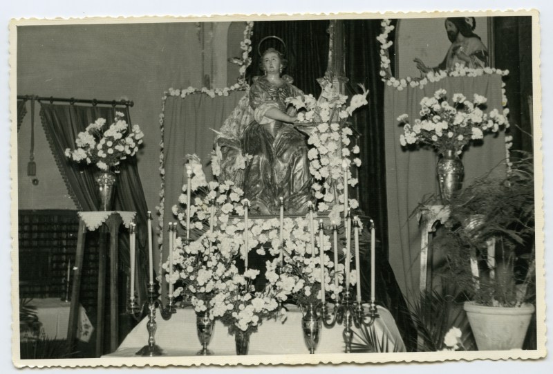 Imagen de Santa Cecilia, de Roque López, con ofrendas florales.