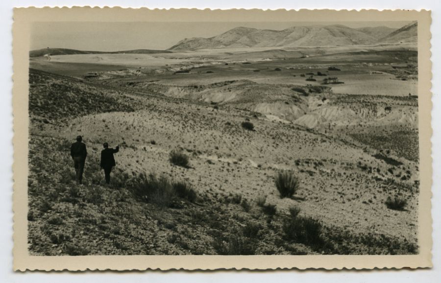 Dos hombres observando un valle desde una ladera