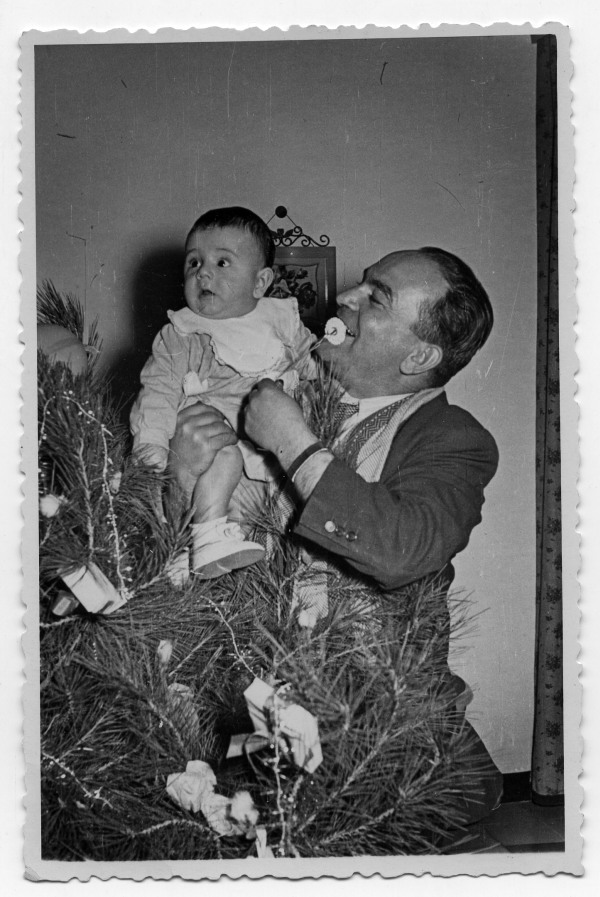 Retrato de Francisco Suárez con un bebé en brazos junto a un árbol de Navidad