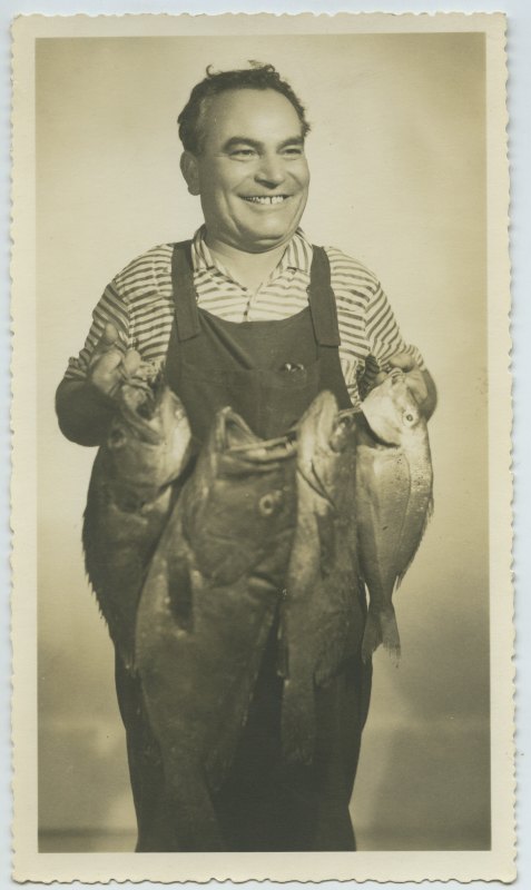 Retrato de estudio de Francisco Suárez sosteniendo un pez
