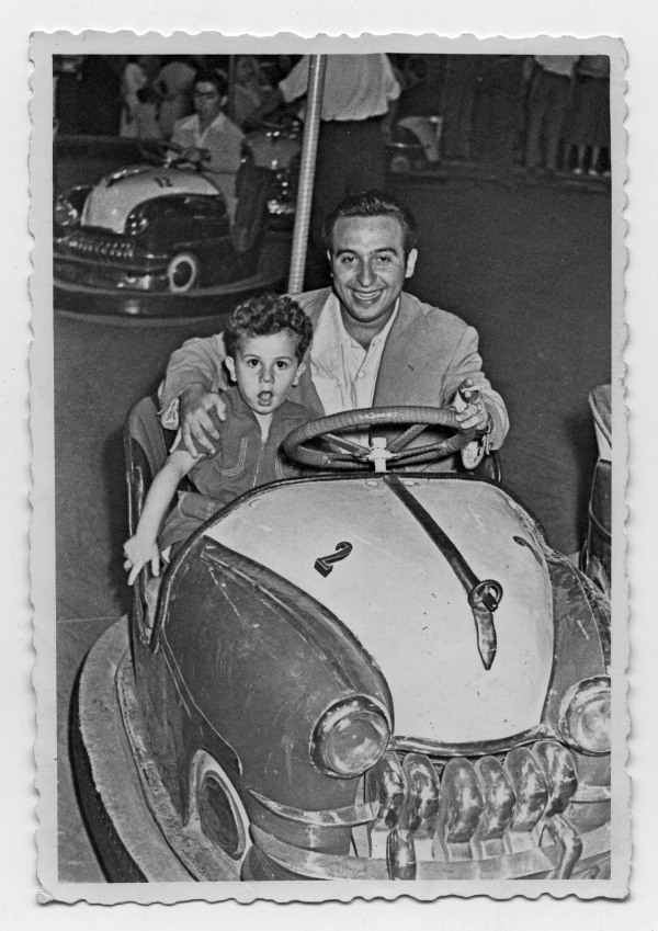 Retrato de Antonio González Olivares con un niño en un coche de choque de la feria