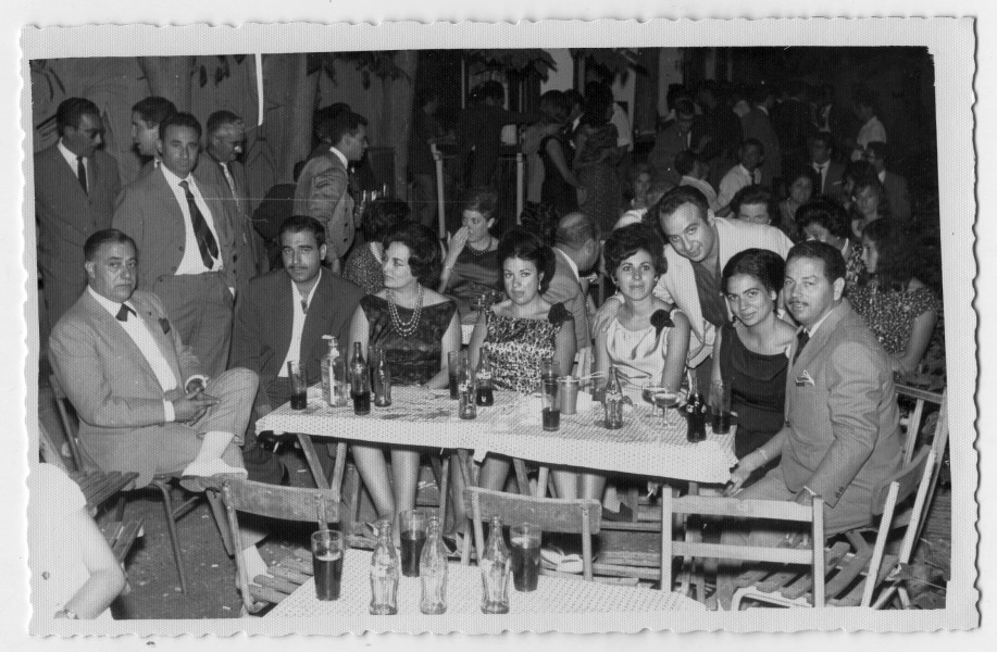Retrato de Antonio González y Francisca Sanz sentados a una mesa con un grupo de amigos durante una fiesta