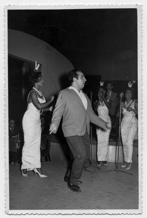 Retrato de Antonio González bailando en el escenario donde actúan tres cantantes