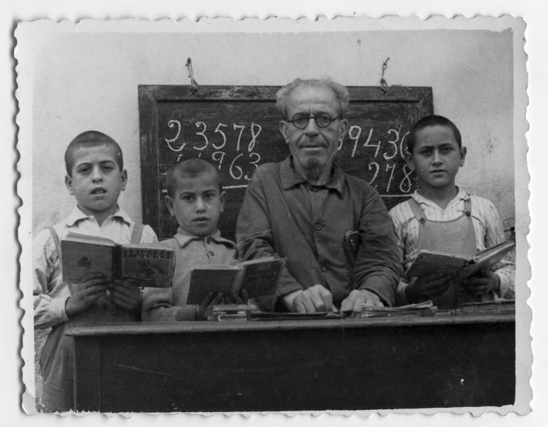 Retrato de Fernando Olivares en un aula con tres alumnos