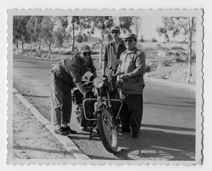 Retrato de Francisco Suárez junto a su moto y dos amigos en una carretera secundaria