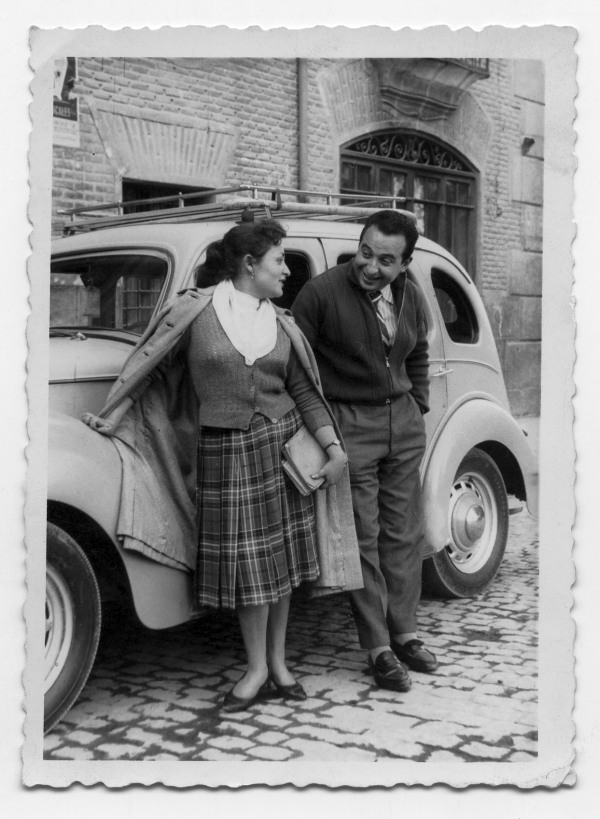 Retrato de Antonio González con una mujer junto a un coche en una calle de Murcia sin identificar