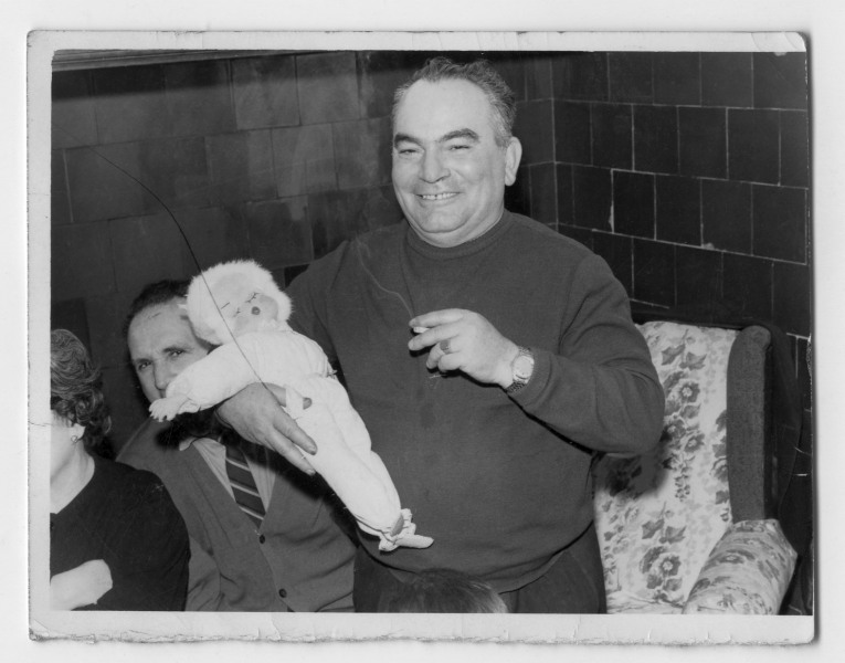 Retrato en interior de Francisco Suárez con una muñeca en brazos