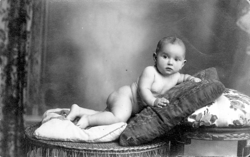 Retrato de bebé sobre cojines.