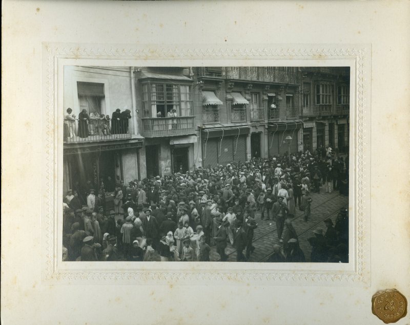 Vista de una multitud haciendo cola para recibir pan ante el comercio de Amorós, en la calle del Carmen de Cartagena
