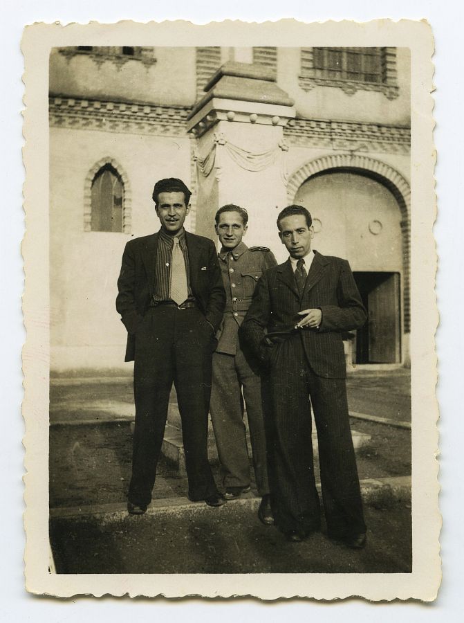 Eduardo Batán, con uniforme, con dos amigos en la plaza de la iglesia de El Palmar.