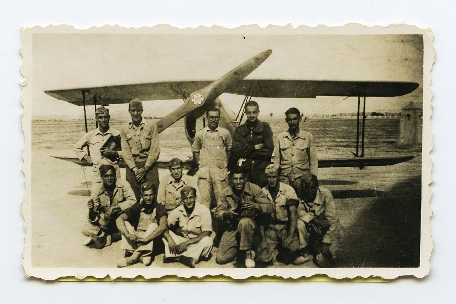 Eduardo Batán con un grupo de compañeros en la pista de un aeródromo, con un avión detrás.