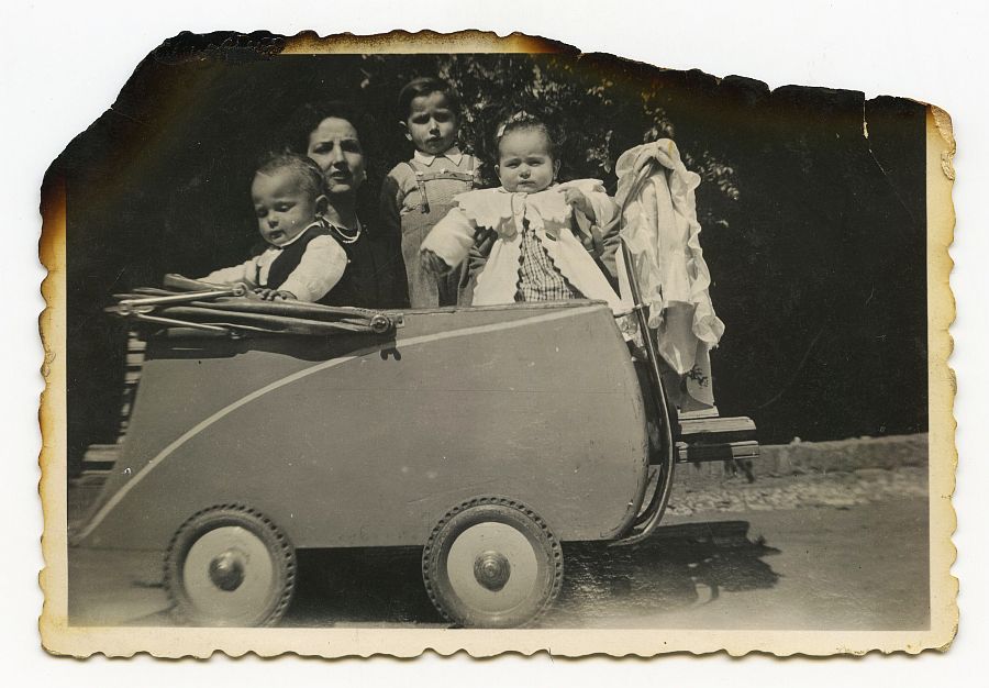 María Saura con sus hijos y otra niña en un carricoche grande en Granada.