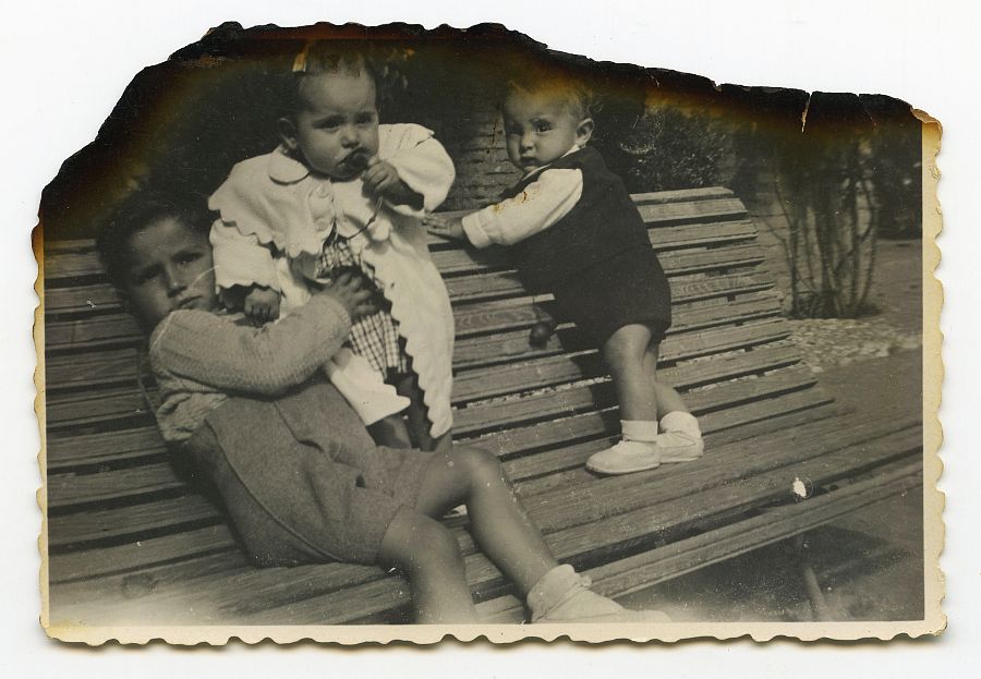 José Luis y Gabriel Batán con otro bebé en el banco de un parque de Granada.