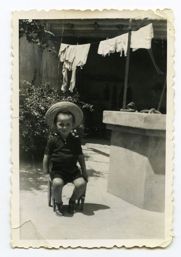 Gabriel Batán, alias Tati, posa sentado con sombrero junto al pozo del patio de su casa en El Palmar.