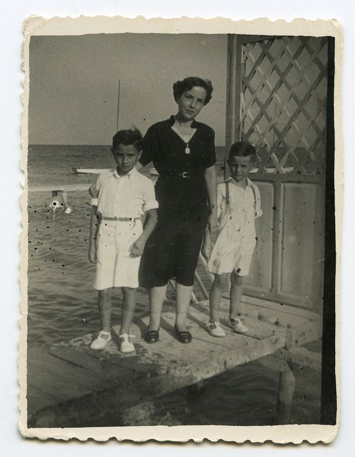 María Saura con sus hijos en una pasarela de madera sobre el agua en Los Alcázares.