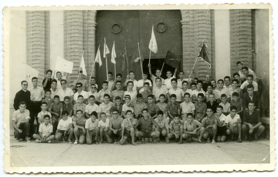 Retrato de un grupo de niños posando delante de la iglesia de El Palmar durante una actividad misional.