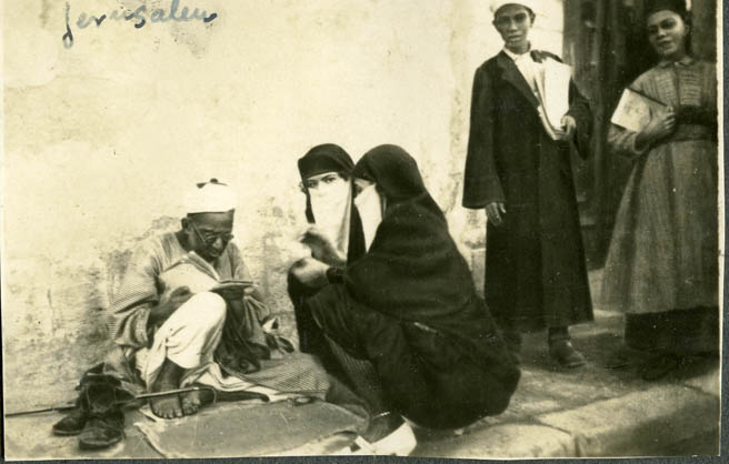 Dos mujeres árabes departiendo con un escribiente callejero. Jerusalén, 1927
