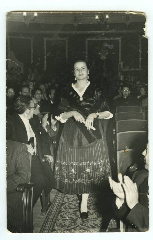Carmen Martí Roch, con traje de jumillana, avanzando por el pasillo del patio de butacas del Teatro Vico de Jumilla