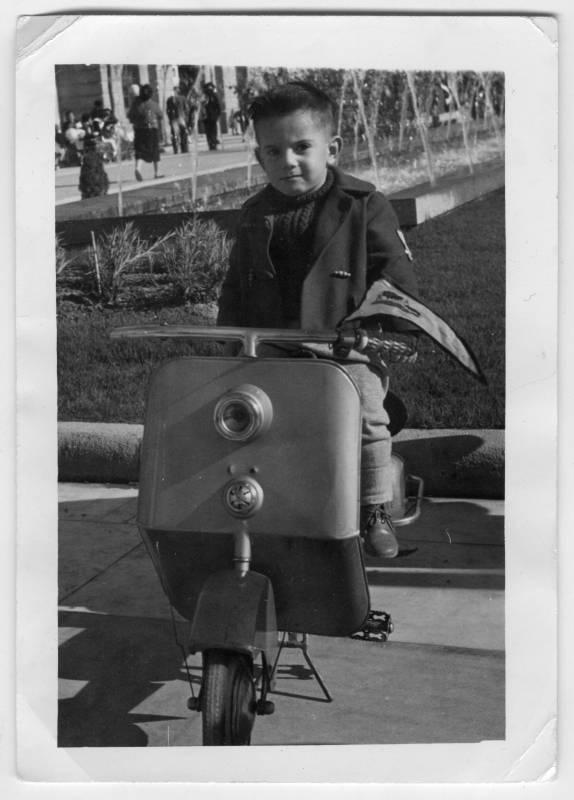 Retrato de un niño en una motocicleta de juguete tipo scooter