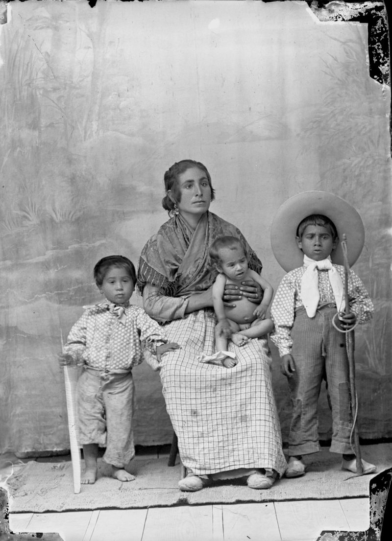 Retrato de mujer de etnia gitana con sus tres hijos.