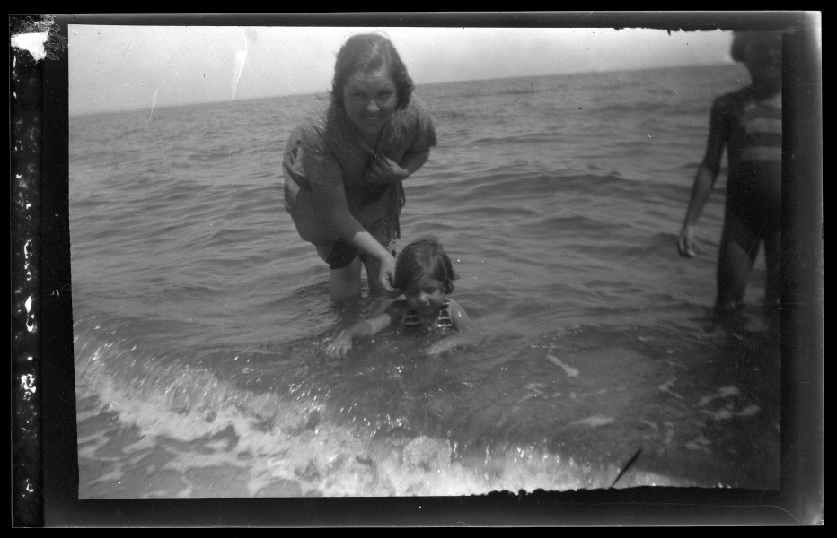 Retrato de una mujer sujetando a una niña de corta edad en la orilla de la playa