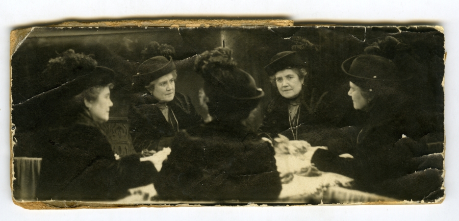 Retrato de un grupo de mujeres sentadas alrededor de una mesa